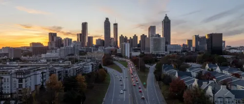 A view of Atlanta's skyline with skyscrapers and in the background and highways in the front at sunset to illustrate public transport in Atlanta.