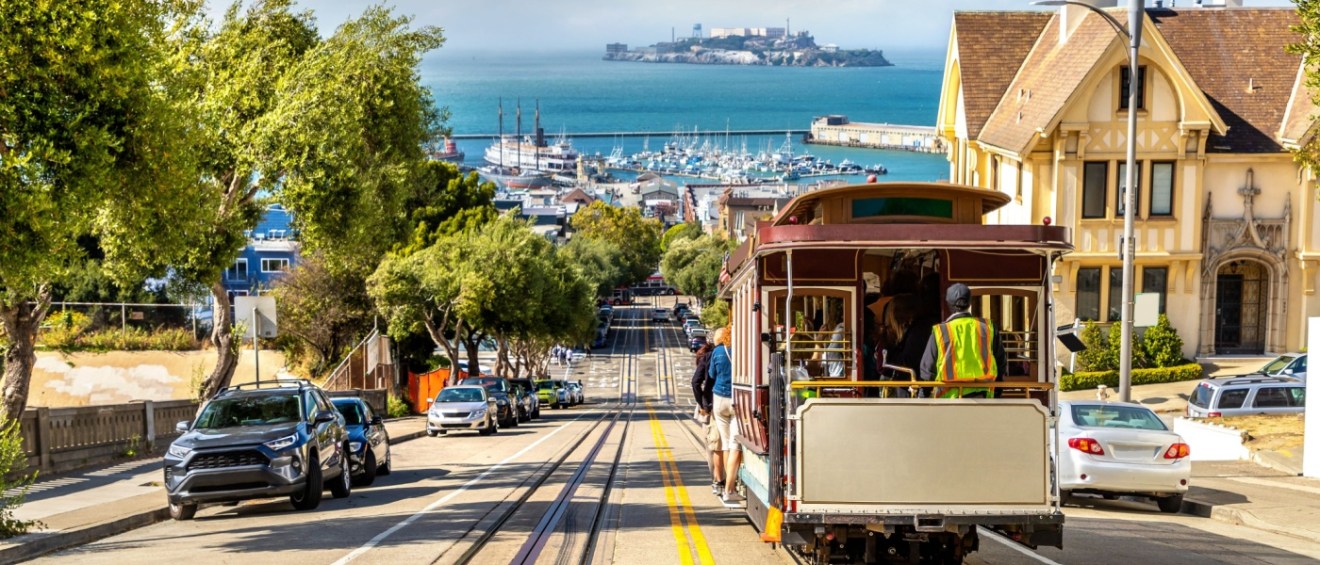 The cable car tram and Alcatraz prison island on a background in San Francisco, California, to illustrate public transport in San Francisco.