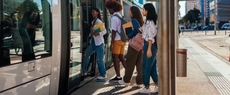 A group of university students boarding a train after class, highlighting the accessibility and efficiency of Sacramento public transit.