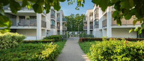 View of apartment buildings and the gate restricting access to the apartments to illustrate what is a gated community apartment.