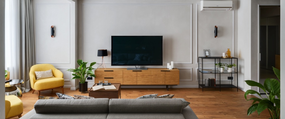 Stylish apartment living room with electronics and lighting that may act as hidden energy vampires, emphasizing energy-saving awareness at home.