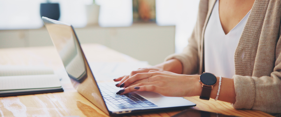 A person using their laptop to send an apartment lease renewal notice to their landlord.