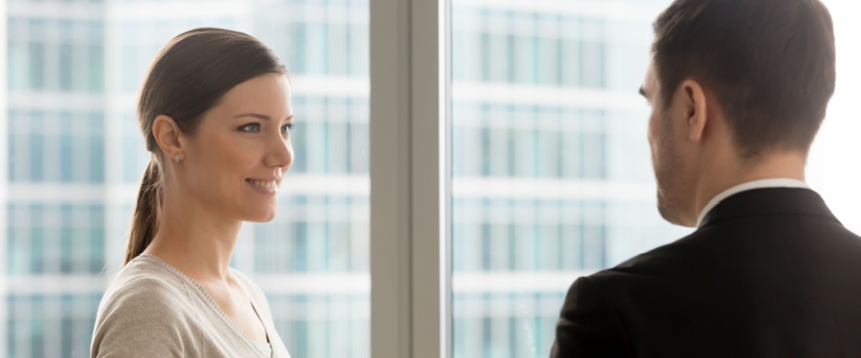 Smiling woman chatting with a landlord, symbolizing professional communication and advice for a first-time renter.