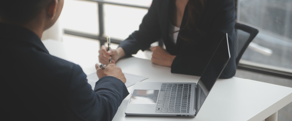 Close-up of employer reviewing a resume during an office interview, symbolizing preparation and organization skills helpful for a first-time renter.