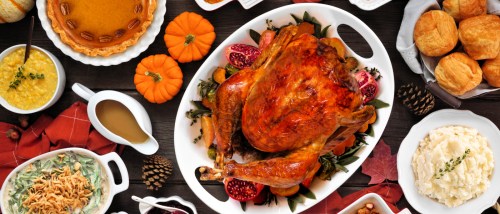A classic Thanksgiving dinner spread, with roast turkey, mashed potatoes, pumpkin pie, and more.