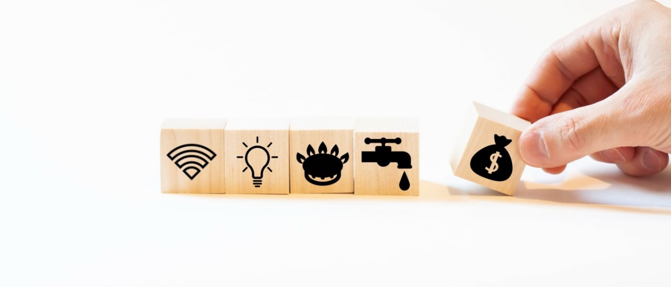 Five wooden cubes lined up, each with a symbol for a specific utility to signal what is RUBS utility billing.