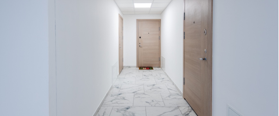 Clean, well-lit apartment building hallway with secured doors, highlighting holiday safety tips for shared spaces and resident security.