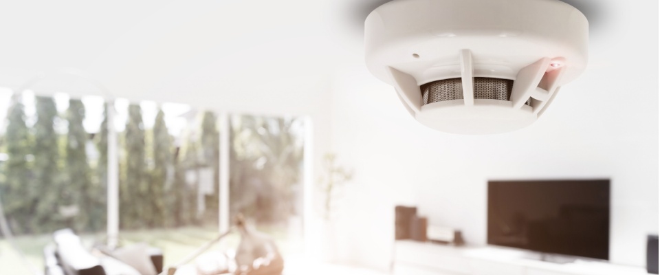 A close-up of a smoke detector on the ceiling of an apartment to illustrate a winter apartment tour.