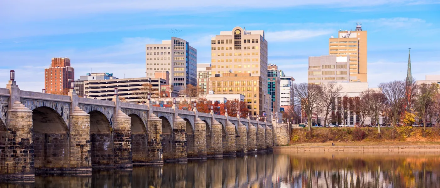Harrisburg, Pennsylvania skyline along the Susquehanna River with colorful fall foliage, illustrating the cost of living in Harrisburg.