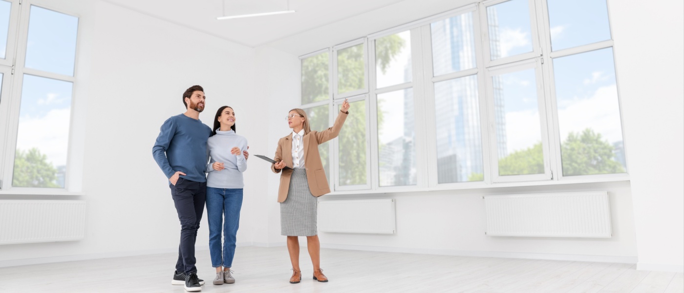 Real estate agent showing new apartment to couple during winter apartment tour.