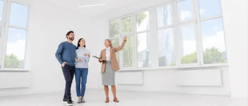Real estate agent showing new apartment to couple during winter apartment tour.