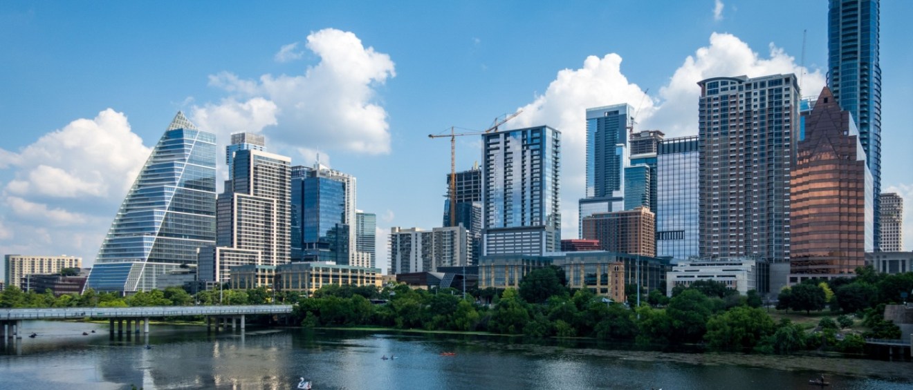 New apartments in Austin along the Colorado River, featuring modern apartment buildings and office towers.