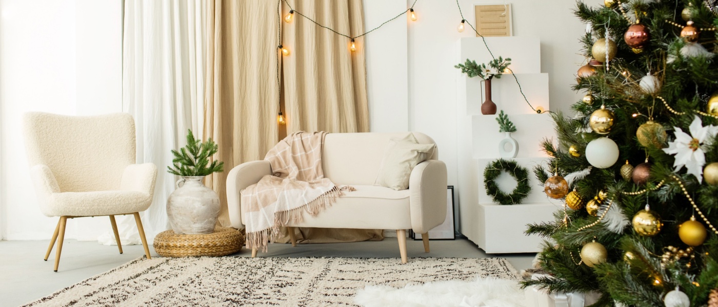 Cozy modern living room decorated for Christmas, featuring a fir tree, wrapped gifts, and holiday toys.