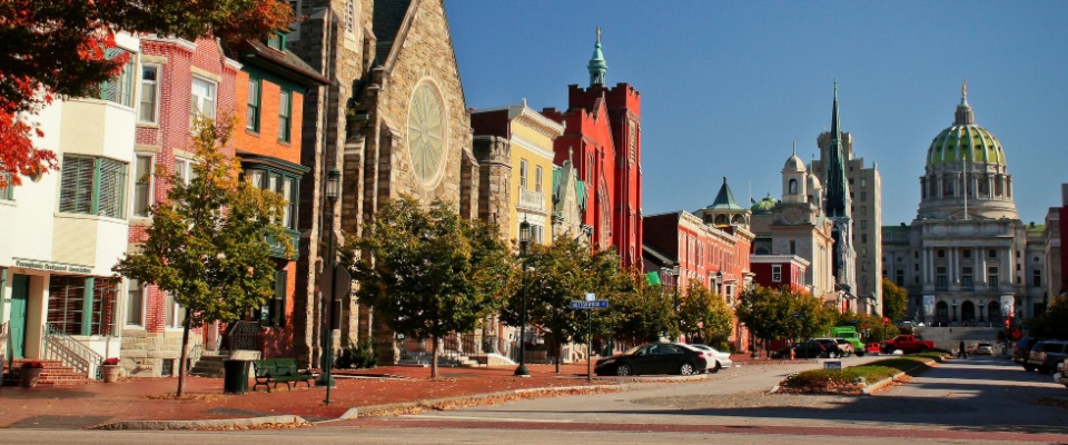 Historic street in Harrisburg, Pennsylvania lined with traditional buildings and autumn trees, representing the cost of living in Harrisburg.