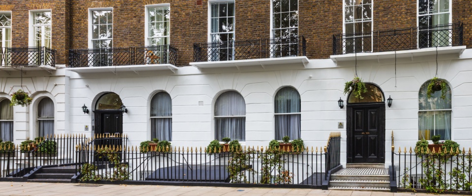 Historic property featuring elegant Georgian-style townhouses, with white façades and black iron railings, showcasing classic residential architecture.