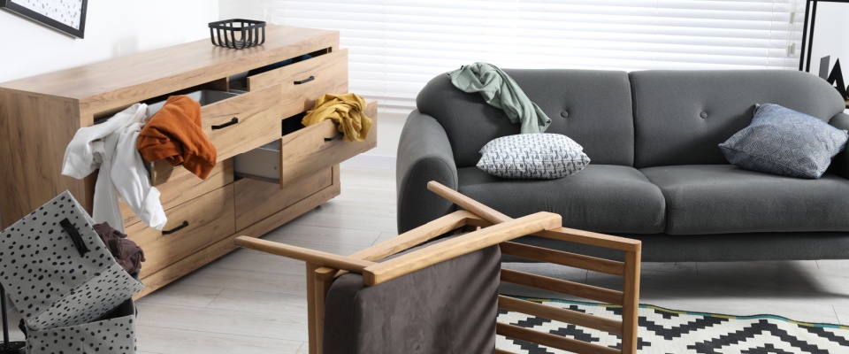 Living room with overturned chair and scattered belongings, representing personal property losses after a theft that renters insurance coverage can help replace.