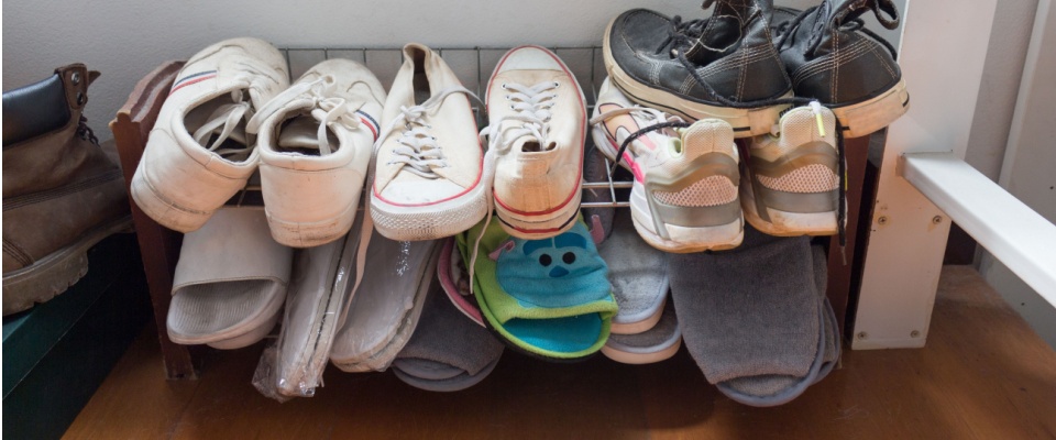 Shoes stored on a low rack at the bottom of a closet, illustrating small closet organization ideas that keep footwear accessible and clutter-free.
