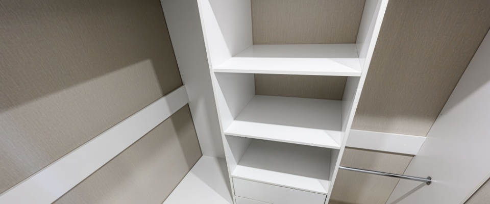 Tall vertical shelving inside a closet, demonstrating small closet organization ideas that use height to increase storage capacity.