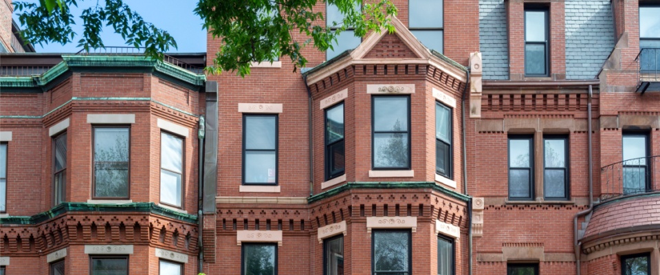Historic property featuring Victorian red brick homes with ornate architectural details along Commonwealth Avenue in Boston, Massachusetts.