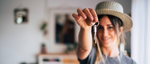 A first timefirst-time renter happily holds the keys to their rental in one hand.