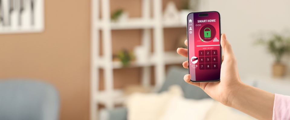 A person holding a smartphone with a smart home security app, illustrating controlled access and safety features renters should look for when renting an apartment in Long Beach, CA.