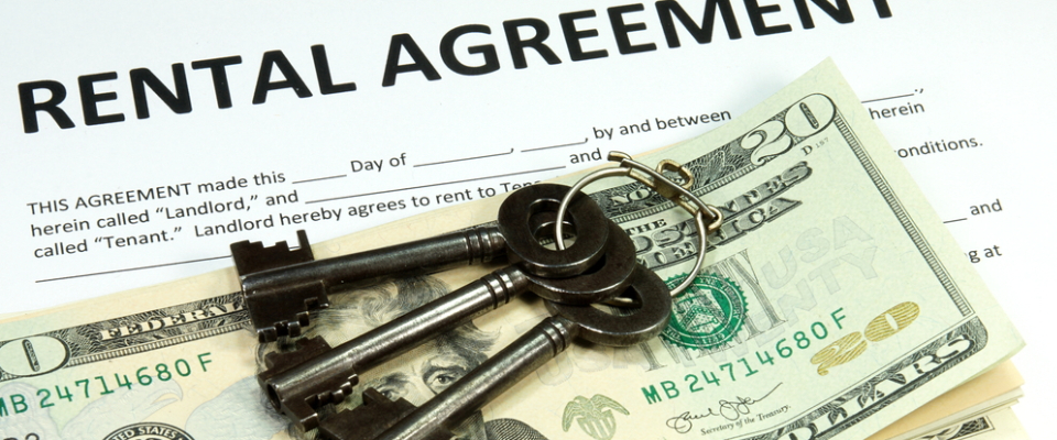 Rental agreement paperwork with keys and cash on top, representing the importance of understanding security deposit rules and lease terms when renting an apartment in Long Beach, CA.