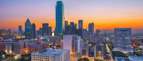 New apartments in Dallas showcased by the downtown Dallas, Texas skyline at dawn, with modern high-rise buildings and a softly lit urban skyline.