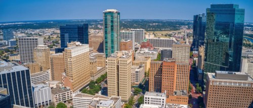 New apartments in Fort Worth highlighted by an aerial summer view of the city, showing modern buildings and the urban skyline of Fort Worth, Texas.