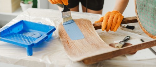 DIY project repainting a wooden chair seat to create colorful and affordable upcycled furniture.