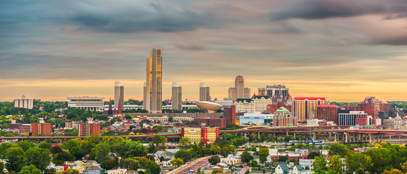 Albany, NY skyline at sunset featuring downtown high-rises, the New York State Capitol complex, and surrounding neighborhoods—highlighting the city’s mix of historic and modern buildings renters should consider before leasing an apartment.