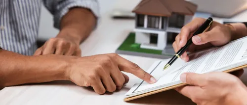 Close up of the hands of two people discussing a contract to illustrate a lease renewal outside the peak season for renting.