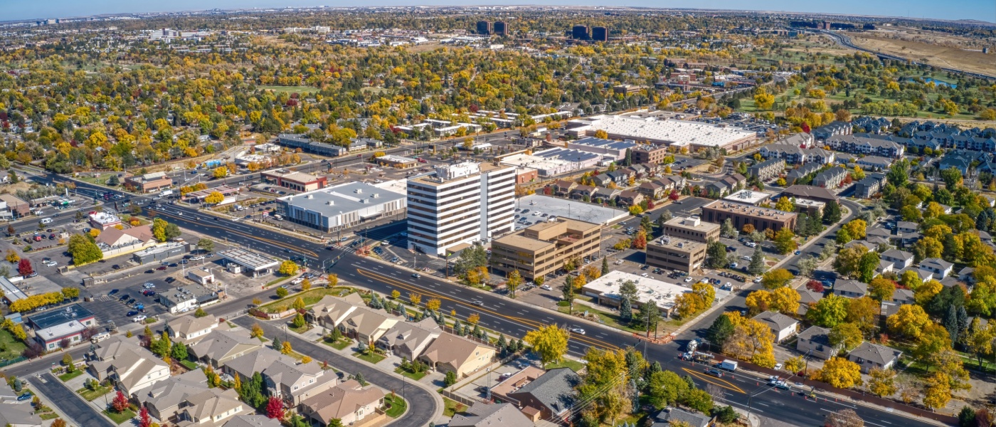 New apartments in Aurora highlighted by an aerial autumn view of the city with colorful foliage and the surrounding Colorado landscape.