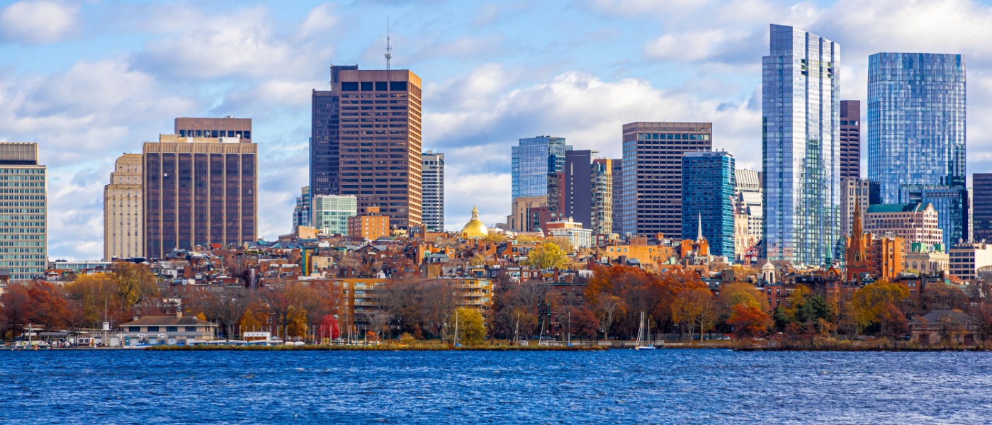 New apartments in Boston highlighted by a panoramic view of the Boston skyline along the Charles River, seen from Longfellow Bridge with clear skies and fall foliage.