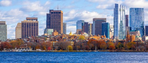 New apartments in Boston highlighted by a panoramic view of the Boston skyline along the Charles River, seen from Longfellow Bridge with clear skies and fall foliage.