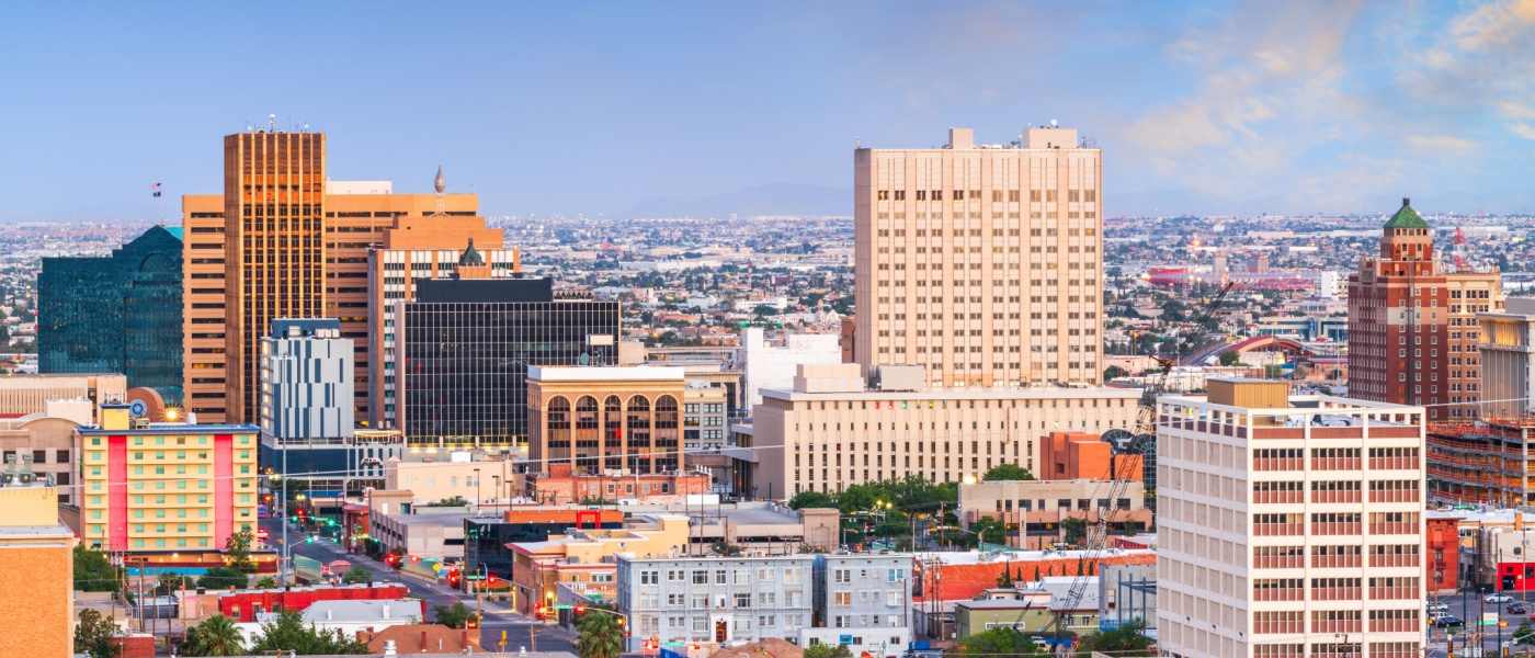 New apartments in El Paso highlighted by the downtown El Paso skyline at dusk, with views extending toward Juarez, Mexico, showcasing urban and cross-border cityscapes.