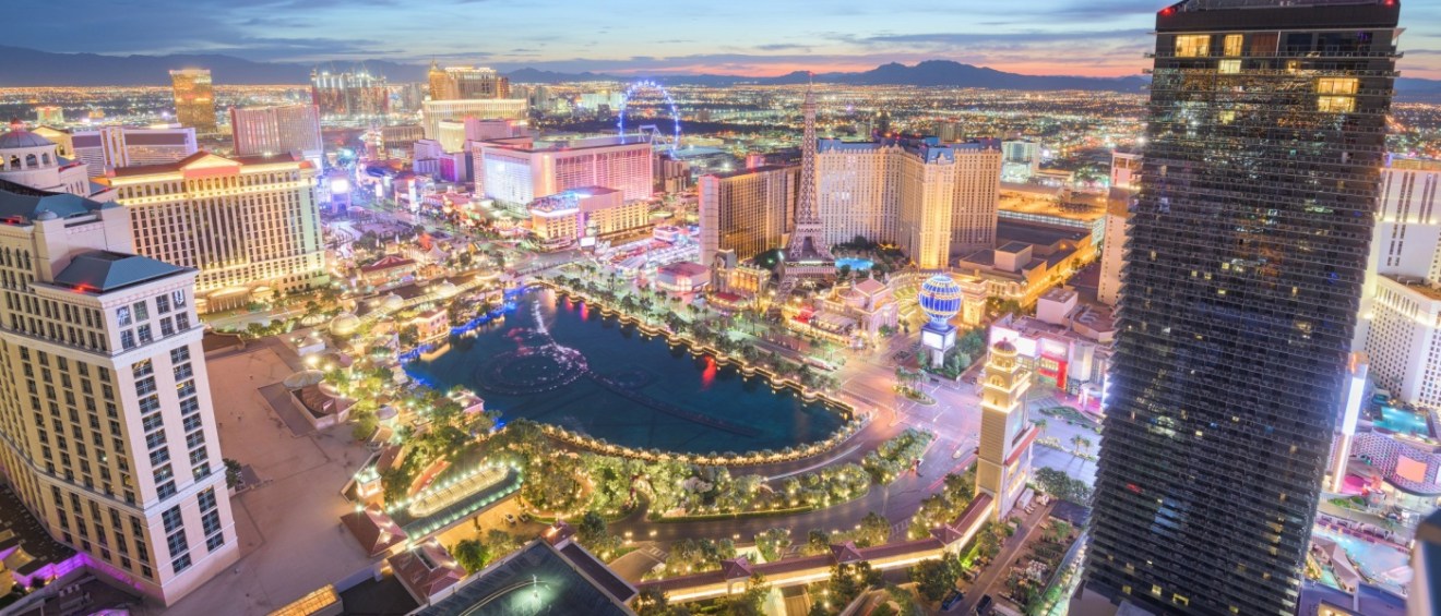 New apartments in Las Vegas highlighted by the city skyline over the Strip at dusk, with illuminated buildings and vibrant evening light.