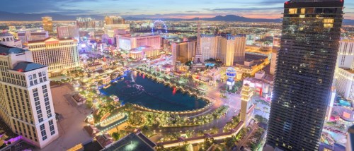 New apartments in Las Vegas highlighted by the city skyline over the Strip at dusk, with illuminated buildings and vibrant evening light.