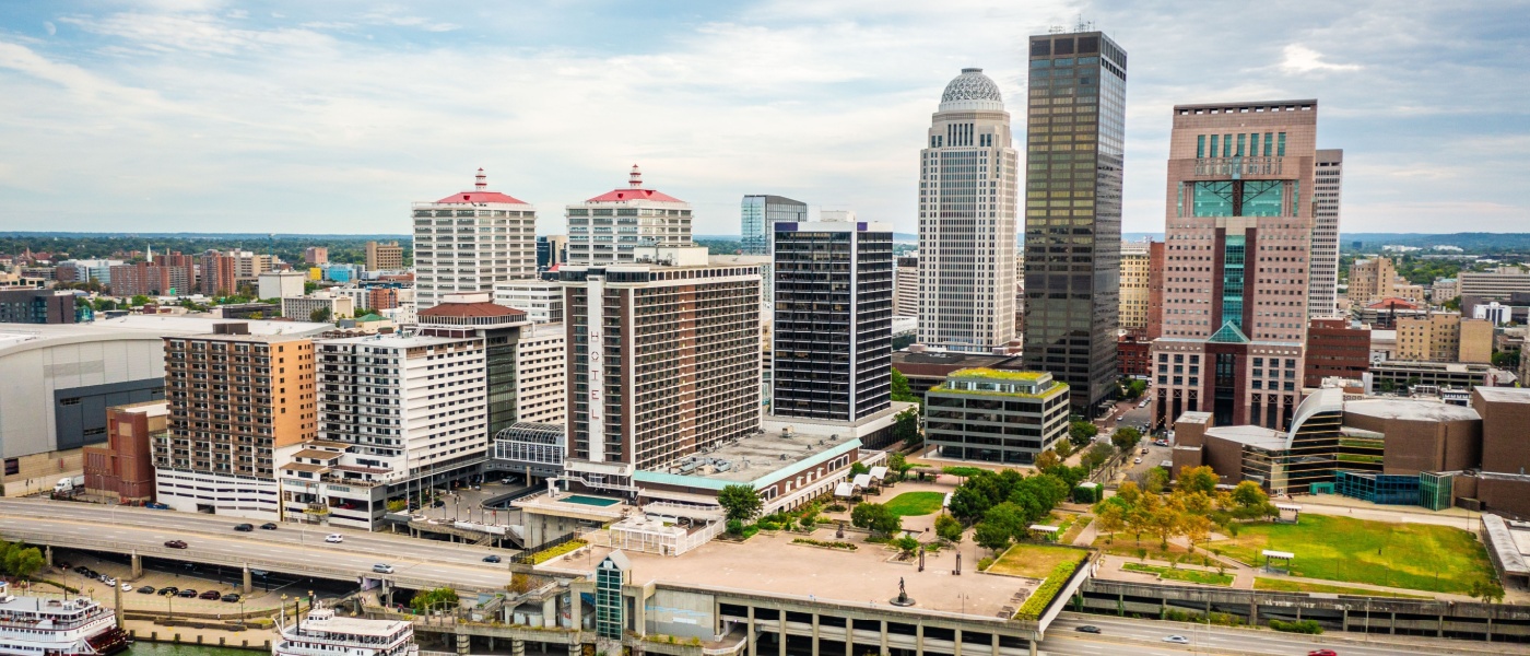 New apartments in Louisville highlighted by an aerial view of downtown Louisville from the Ohio River, showcasing the city’s skyline and waterfront setting.