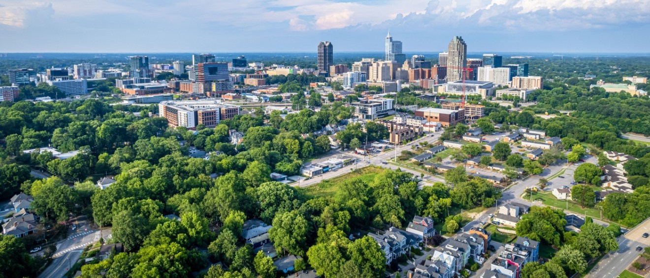 New apartments in Raleigh highlighted by a clear view of the downtown skyline against a bright blue sky in Raleigh, North Carolina.
