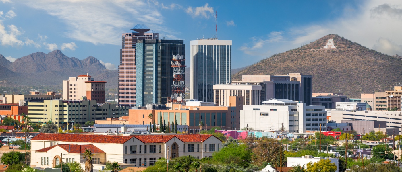 New apartments in Tucson highlighted by the downtown skyline in the afternoon, featuring city buildings against the desert backdrop.