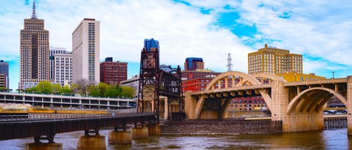 St. Paul, Minnesota skyline with skyscrapers and the Robert Street Bridge over the Mississippi River, highlighting city infrastructure and public transit connections in the urban area.