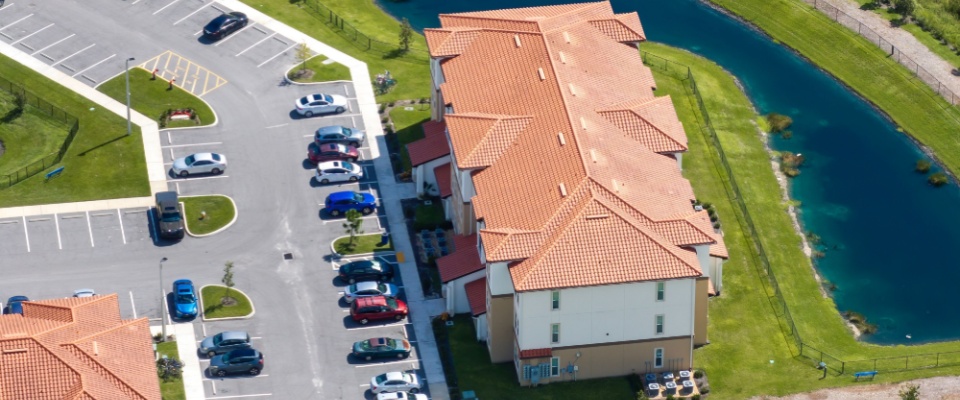 American apartment buildings in Florida with parking lots and landscaped residential zone in suburban community to illustrate renting an apartment in Port St. Lucie, Florida.