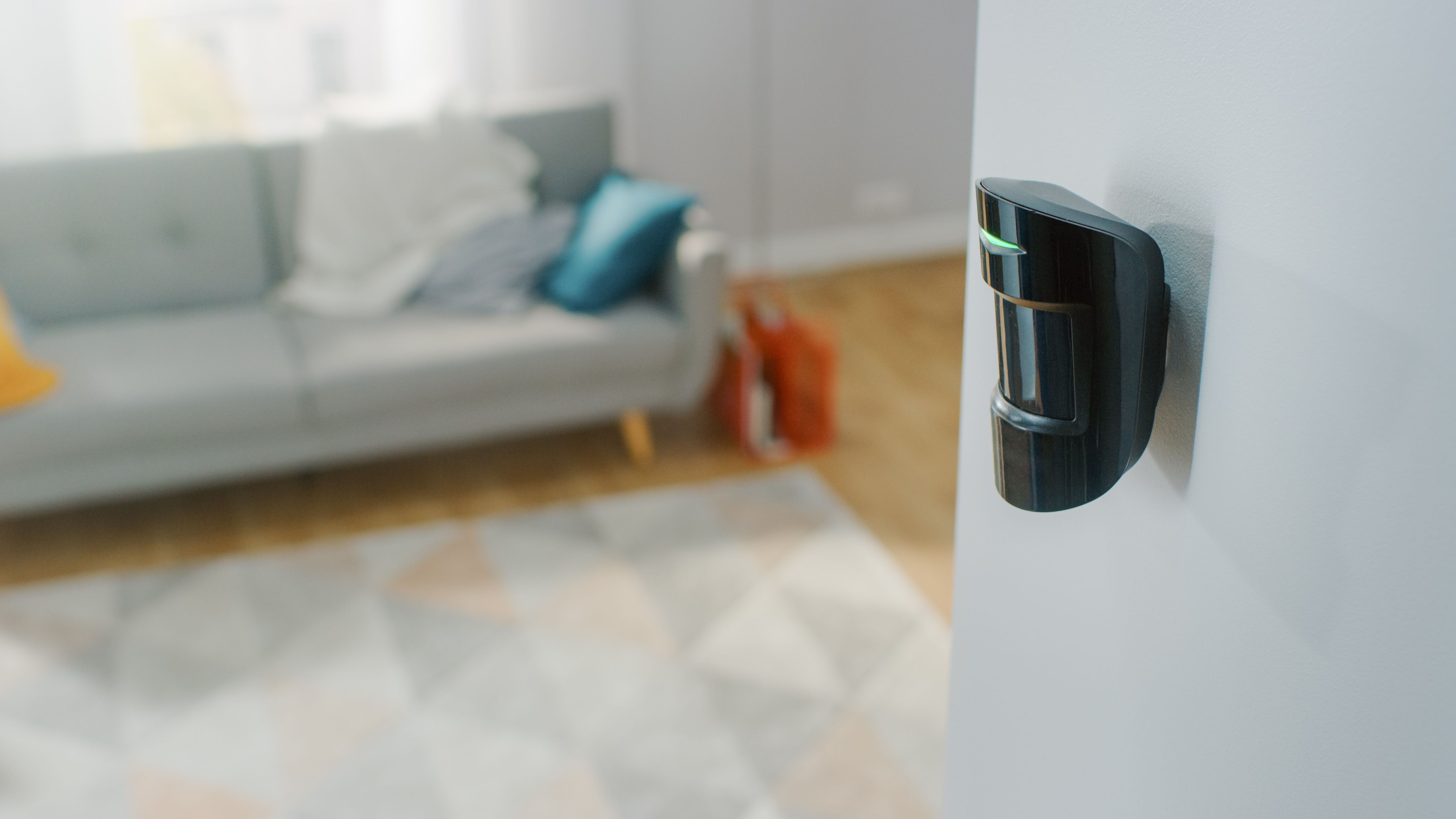 Wall-mounted motion sensor inside a living room, showing how smart home devices enhance home security and monitor activity.