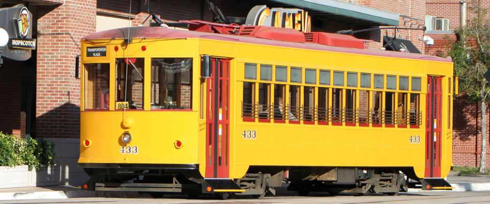 Yellow TECO Line Streetcar operating in downtown Tampa, showing a key Tampa public transport option connecting Ybor City, the Channel District, and downtown neighborhoods for renters.