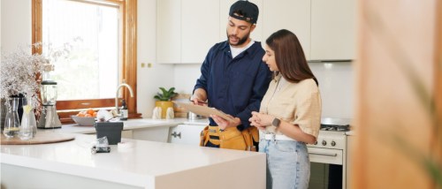 Woman, kitchen and plumber with contract on clipboard for maintenance service, information and repairs to illustrate how and why to submit a maintenance request.