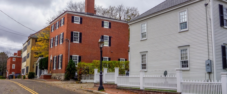 Charming historic street in Portsmouth, New Hampshire, with colonial-style buildings, representing the appeal of moving to a new neighborhood.