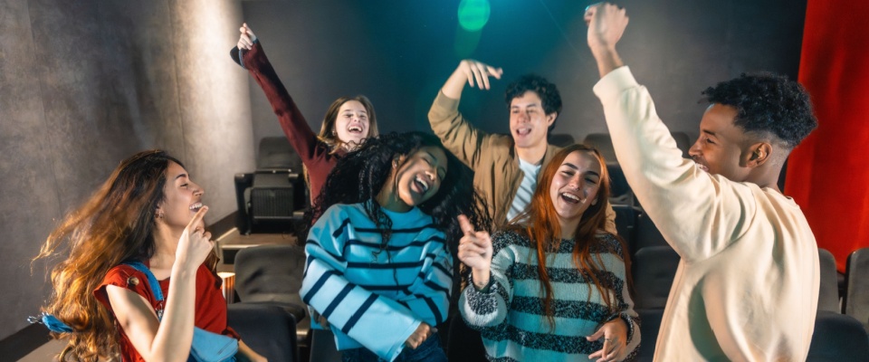 A group of friends enjoying themselves in an apartment building media room.