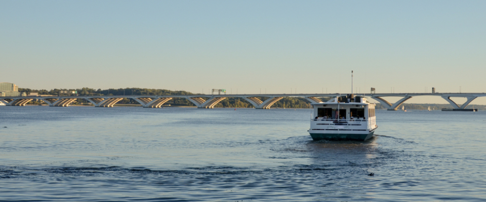 Water taxi crossing the Potomac River near Alexandria, VA with the Woodrow Wilson Bridge in the background, one of several Alexandria public transport options available to renters.