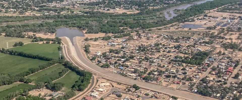 Aerial view of Albuquerque neighborhood near an arroyo and drainage channel, emphasizing flood risk considerations when renting in Albuquerque, NM.