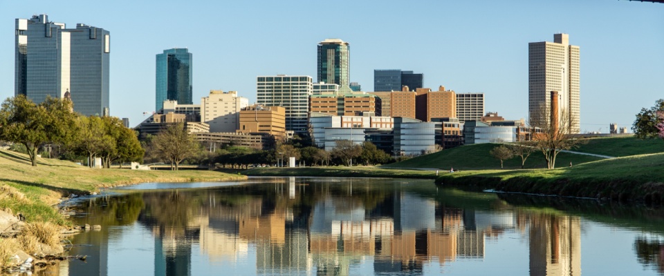 A waterfront view of the skyline in Fort Worth, TX, a city where the cost of living is below the U.S. average.